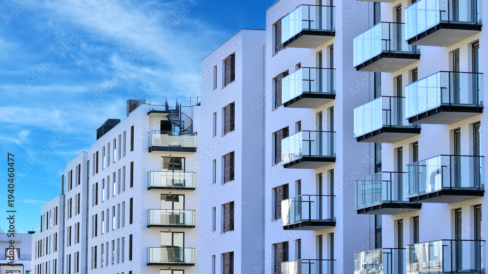 Fototapeta premium Modern apartment buildings on a sunny day with a blue sky. Facade of a modern apartment building. Glass surface with sunlight.