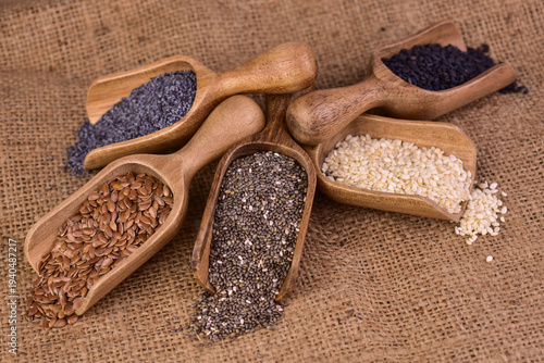 Healthy seeds - sesame, flaxseed, chia seeds, hemp seed and black sesame seed in wooden spoons. View from above