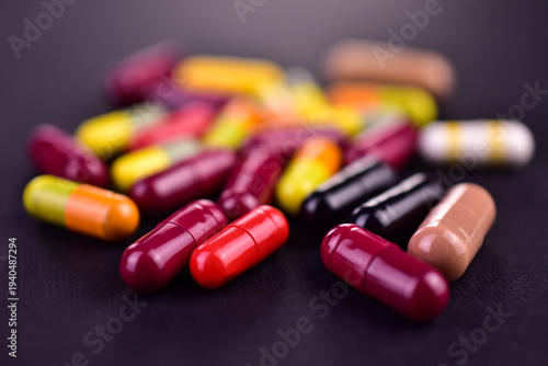 Various capsules on a black background. Selective focus. Medicines.