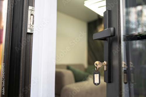 фотографія room door slightly ajar with a key left in the lock, revealing part of a cozy sofa inside, hinting at welcoming accommodation
