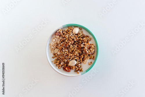 Healthy breakfast bowl with yogurt, granola, almonds and seeds, top view copy space