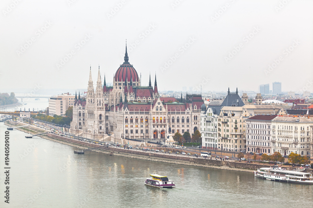 Fototapeta premium Hungarian Parliament Building in Budapest, an architectural marvel on the Danube bank. Neo Gothic structure grand dome and intricate spires dominate the scenic city skyline