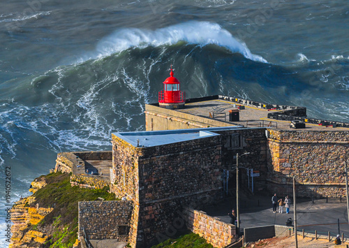 Large ocean swell approaching Nazare lighthouse Portugal
