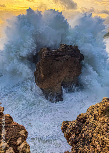 Massive Atlantic wave exploding over sea stack at Nazare