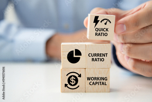 Hand stacks wooden cubes with business finance terms quick ratio current ratio and working capital illustrating financial health concept