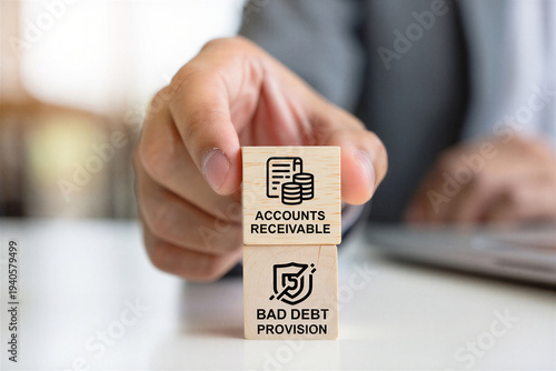 Person holding wooden blocks with accounting icons representing accounts receivable and bad debt provision concept