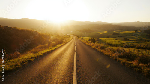 Empty mountain road disappearing into morning fog under a wide sky in a natural landscape