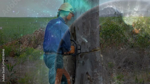 Male worker placing chainsaw on bark, cutting trunk for forestry while cosmic overlay drifting