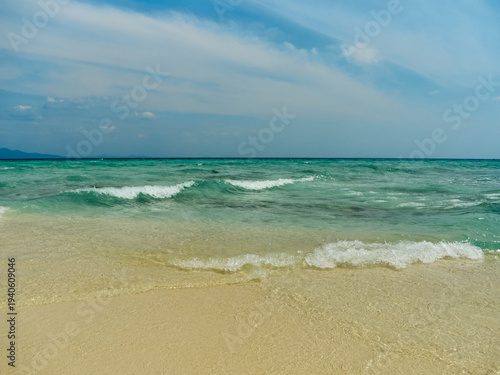 The coast of the Andaman Sea, crystal clear sea water and yellow sand on the beach, the sea is slightly rough, a beautiful seascape