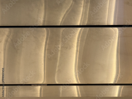 A shiny, metallic surface with a pattern that resembles waves