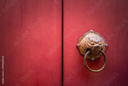 Antique style handle knocker of the Chinese templeWooden red door with Chinese style of lion head doorknobDragon head or lion head knocker made from brass on red wooden door, Chinese temple