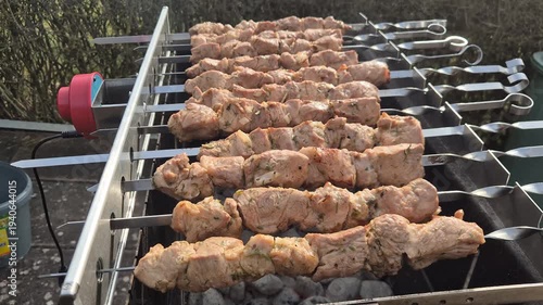 The kebabs are grilled on the coals while rotating.