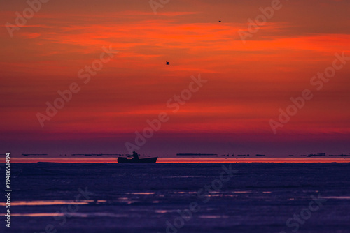 Fisherman checking on nets on the cold March sunrise.