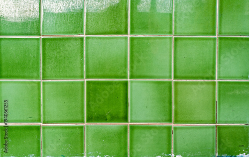 Detail of  green tiles lining the exterior wall of a building