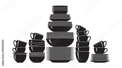 A neatly arranged pyramid stack of black and white dishes including bowls, plates, and cups on a clean surface viewed from the front