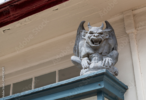 Cuadro en lienzo A stone gothic gargoyle sculpture perched on a historic building facade