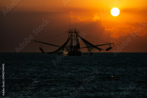 Cuadro en lienzo Golden Harvest: Silhouette of a Shrimp Boat at Sunset off the Coast of Key West