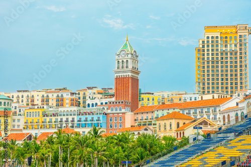 Colorful mediterranean style resort buildings and clock tower with palm trees in Sunset Town, Phu Quoc island, Vietnam. Coastal resort development and tourism infrastructure