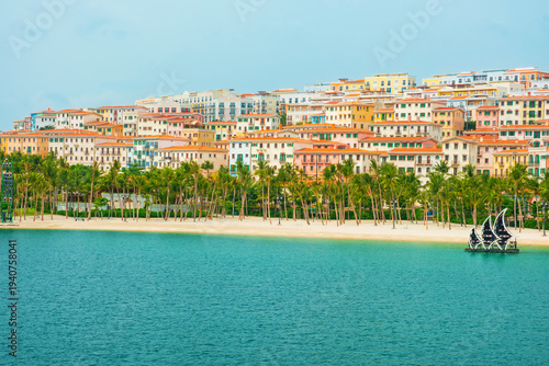 Colorful mediterranean style resort buildings along beach with palm trees and turquoise sea in Sunset Town, Phu Quoc island, Vietnam. Italian architecture in Asia. Travel and touristic destination