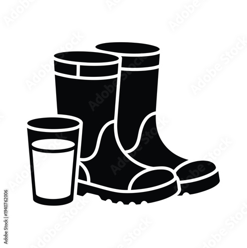 A pair of black rubber boots and a glass of water on a white background