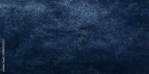 Detailed dark blue denim fabric texture showing a rough cotton textile material surface with a grunge pattern design for a fashion clothing backdrop