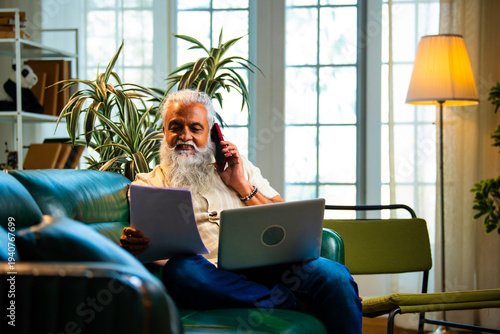 Modern Indian entrepreneur managing calls and paperwork at home