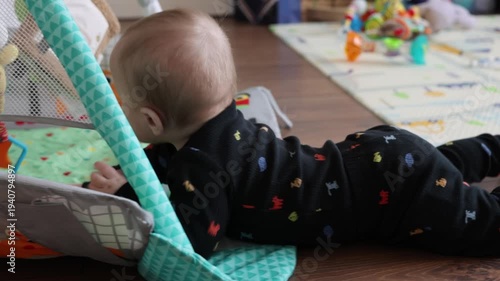Infant Explores Play. Baby Practices Motor Skills Kindly. Child Interacts With Hanging Toys Cheerfully