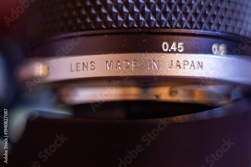 A detailed view of an old camera lens with engraved text made in Japan