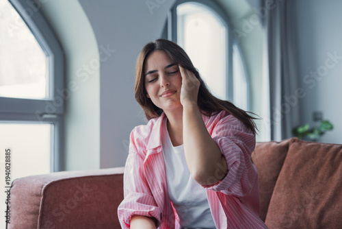 Fényképezés A depressed and frustrated young Caucasian woman sits with her eyes closed, touc