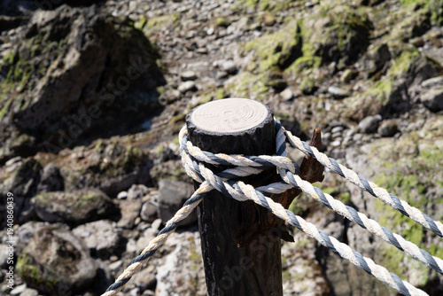 Foto Mooring rope tied around harbor post
港の係留柱に巻かれたロープ