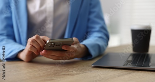 Canvastavla Woman sending text message via smartphone at wooden desk indoors, closeup