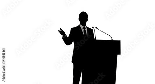 Silhouette of a man speaking at a podium with microphones.