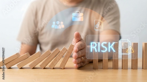 A person's hand is proactively preventing a line of wooden dominoes from collapsing, symbolizing effective risk management and crucial incident prevention strategies.