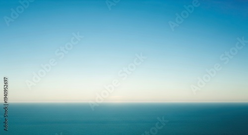 Calm ocean waters under a serene blue gradient sky at sunrise or sunset with gentle waves and a peaceful atmosphere