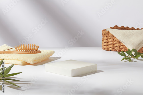 Haircare items arranged on white blocks with basket and brush, soft shadow background for cosmetic branding. Space for presentation product