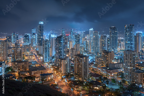 Wallpaper Mural Aerial panoramic view of downtown city skyline at night with illuminated skyscraper buildings and streets glowing under cloudy sky creating vibrant urban atmosphere Torontodigital.ca