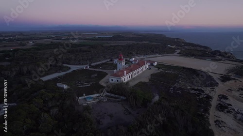 Farol do Cabo Sardão lighthouse complex on dramatic Atlantic cliffs of Costa Vicentina in São Teotónio Odemira Alentejo Portugal overlooking marine reserve and rocky shoreline, smooth drone orbit
