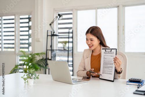 Young asian business woman talking with client online presents insurance contract , sitting in front of laptop, female officer working remotely from office.