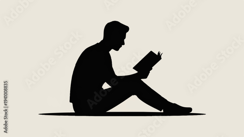 Man sitting cross legged reading book in relaxed pose on floor with plain background