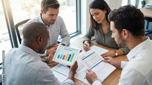 Diverse team analyzing financial reports in modern office setting