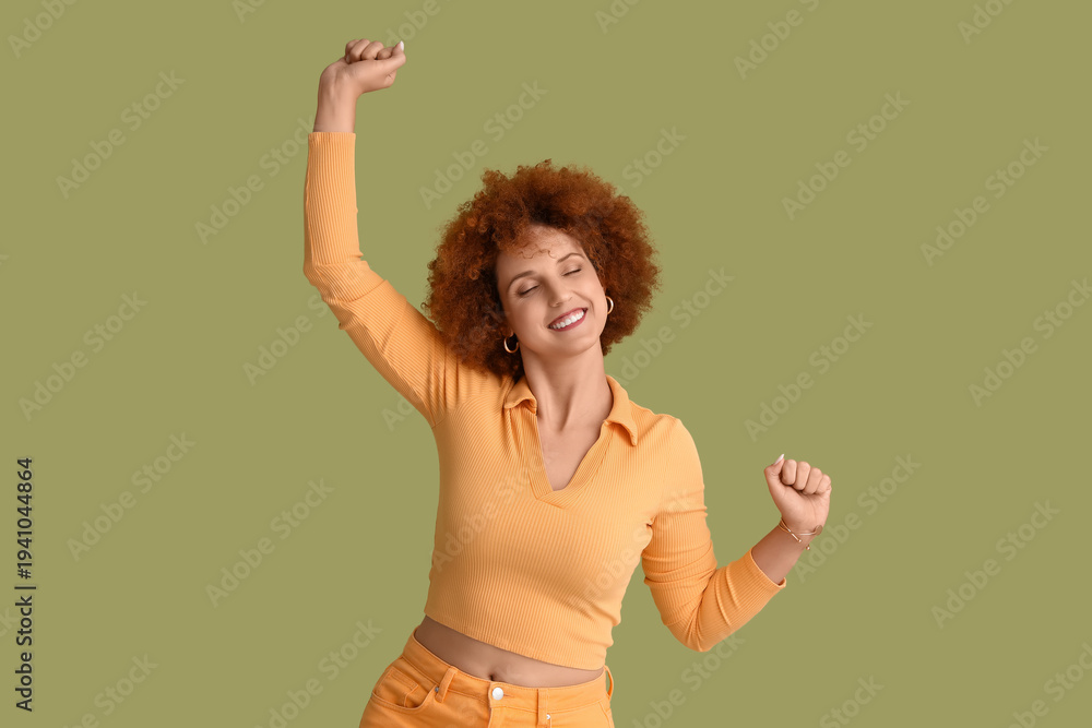 Fototapeta premium Happy redhead young woman with curly hair on green background