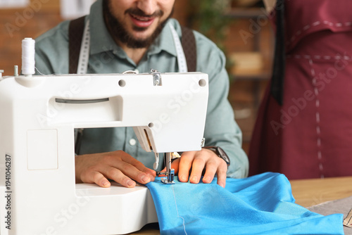 Male tailor sewing clothes ...