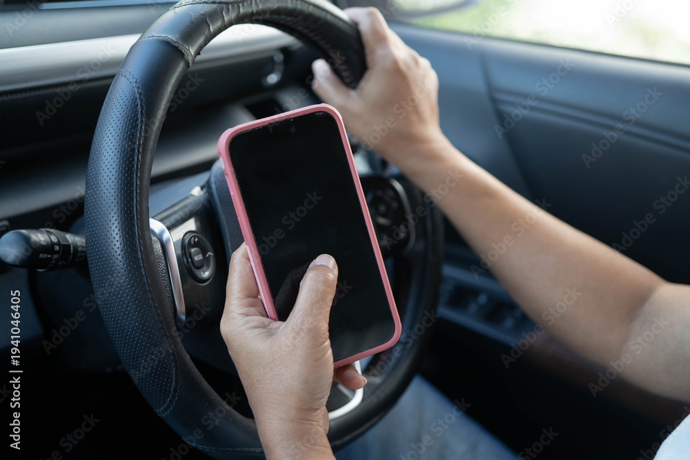 Naklejka premium Driver holding smartphone using map app for navigation in car.