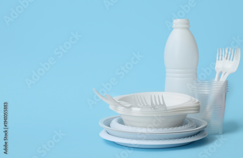 Bilde på lerret White plastic tableware on light blue background