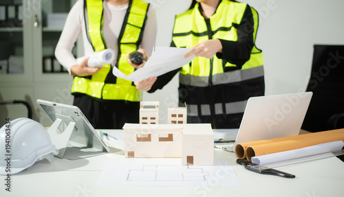 Engineer teams meeting working together wear worker helmets hardhat on construction site in modern city.
