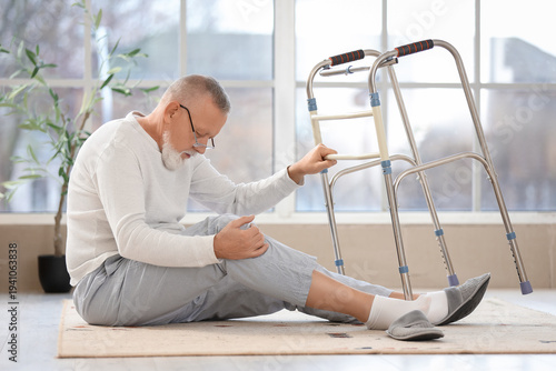Senior man sitting on floor...