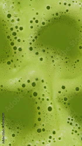 Close-up of frothy matcha green tea being whisked, seamless loop