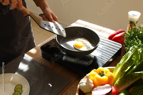 Woman frying tasty chicken ...