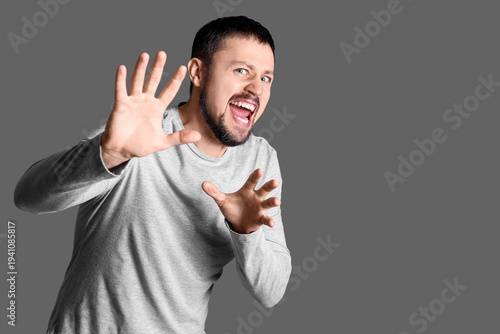 Screaming young man on dark...