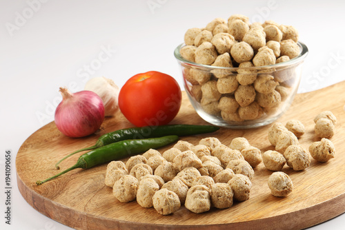 Raw soya chunks ,garlic ,green chilli, onion, tomato, on cutting board . Healthy, nutritious soybean meat, chunks Vegan food concept.  known as soya wadi or meal maker in India
